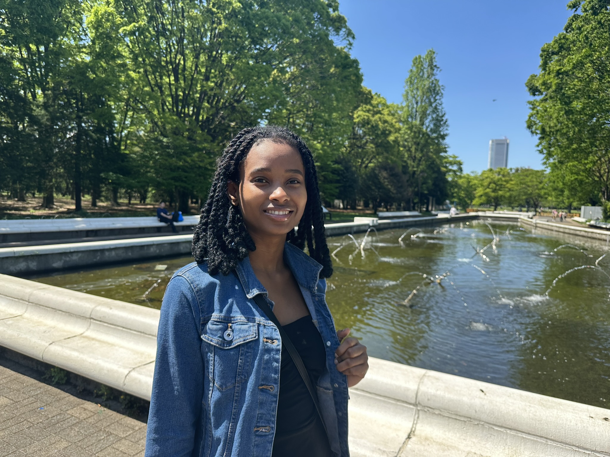 Chaïda smiling beside a fountain in Tokyo